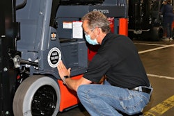 Toyota associate applies commemorative placard, completing the assembly of the milestone 750,000 forklift to roll off Toyota Material Handling's production line in Columbus, Indiana.