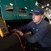 A specially trained and certified technician at Volvo Trucks TEC Equipment’s Fontana, California dealership location checks the battery voltage on a Volvo VNR Electric.