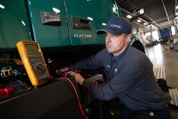 A specially trained and certified technician at Volvo Trucks TEC Equipment’s Fontana, California dealership location checks the battery voltage on a Volvo VNR Electric.