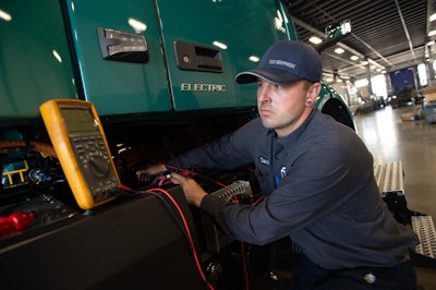 A specially trained and certified technician at Volvo Trucks TEC Equipment’s Fontana, California dealership location checks the battery voltage on a Volvo VNR Electric.
