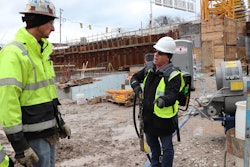 Greg Ramer (right), sales manager for Wacker Neuson explains the advantages of Wacker Neuson’s ACBe battery-powered backpack vibrator to Jeff Kremel, site superintendent for J. H. Findorff & Son, general contractor for the Couture site.