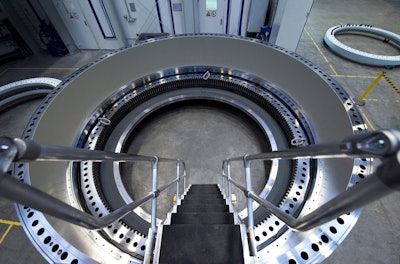 The inside of the large diameter bearing for maritime applications is visible from a ladder.