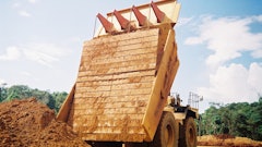 Carryback works against efficiency by reducing payload in the haul truck as residual material is left sticking to the sides and bottom of the truck, decreasing hauling capacity for subsequent loads.