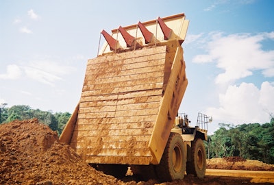 Carryback works against efficiency by reducing payload in the haul truck as residual material is left sticking to the sides and bottom of the truck, decreasing hauling capacity for subsequent loads.