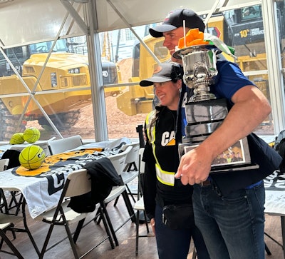 Patrick Doheny, right, of Australia took home the largest trophy as the world champion of the Caterpillar Global Operator Challenge at 2023 CONEXPO.