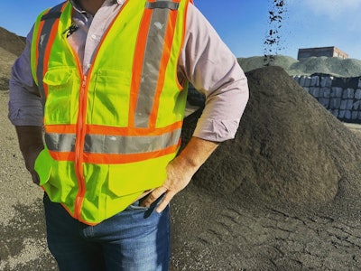 Jim McMurray standing in front of his pile of 'black sand'