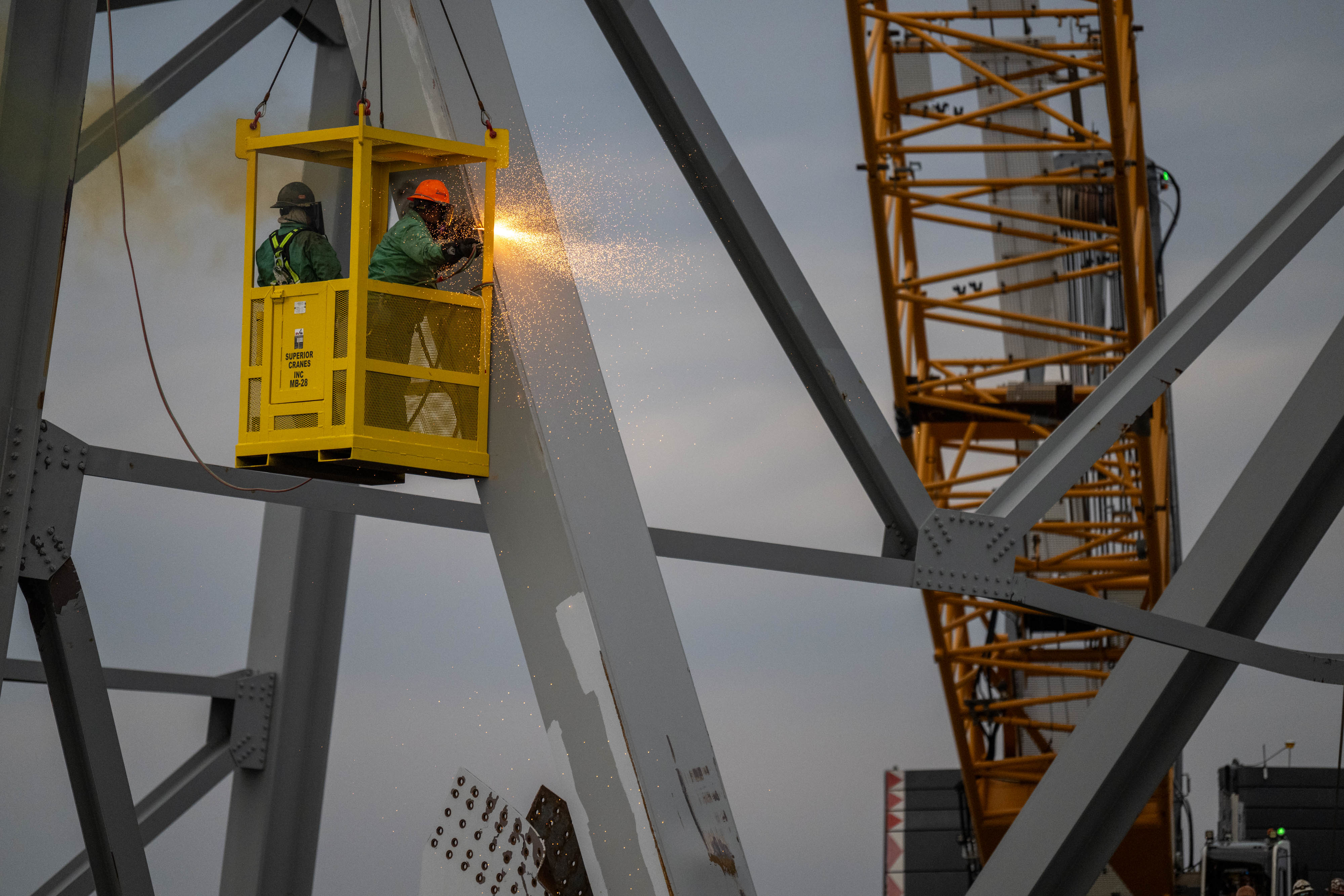 Demolition crews with the Unified Command begin cutting the top portion of the north side of the collapsed bridge into smaller sections for safe removal by crane in the Patapsco River, in Baltimore, Maryland, March 30, 2024. Salvage teams use exothermic cutting torch to systematically separate sections of the steel bridge, which will be taken to a disposal site.
