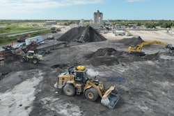 Teleo-equipped Caterpillar wheel loader operating in the midst of other operations across an Ajax Paving asphalt plant.