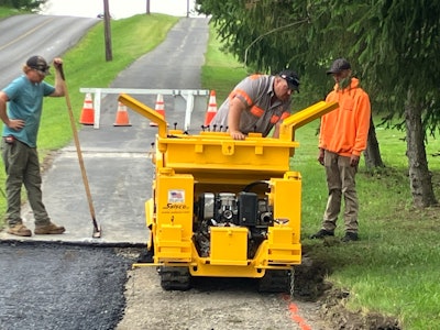 Pave Care employees Joe Dillaman (on the mini paver), Claude White Side (in orange hoodie), and Todd McConell patching a walking trail at Slippery Rock University.