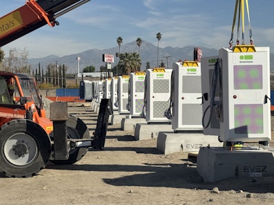 EV chargers being installed onto concrete bases.