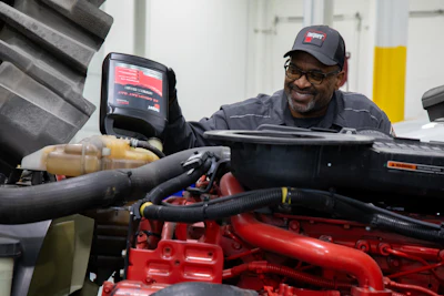 Fleetguard Aa Man Pouring Coolant Smiling