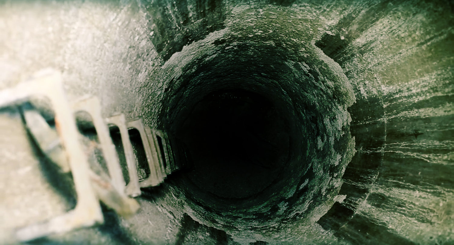 Microbially-induced corrosion in concrete creates extensive surface degradation, which can lead to widespread structural deterioration over time.