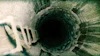 Microbially-induced corrosion in concrete creates extensive surface degradation, which can lead to widespread structural deterioration over time.