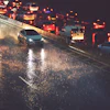 Heavy traffic on wet highway at night with vehicle headlights and taillights reflecting on rain-soaked pavement