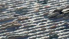 Aerial view of ridged terrain with shadow patterns creating natural linear formations across the landscape