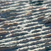 Aerial view of ridged terrain with shadow patterns creating natural linear formations across the landscape