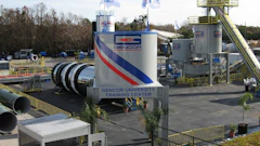 Gencor University Training Center industrial facility with blue and red striped branding, equipment towers, and flags