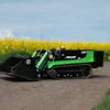 Green and black tracked mini loader positioned on a rural road with yellow rapeseed field in background