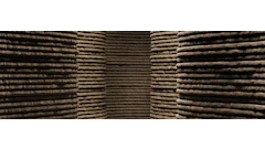 Stacked wooden logs arranged in organized rows at a timber storage facility