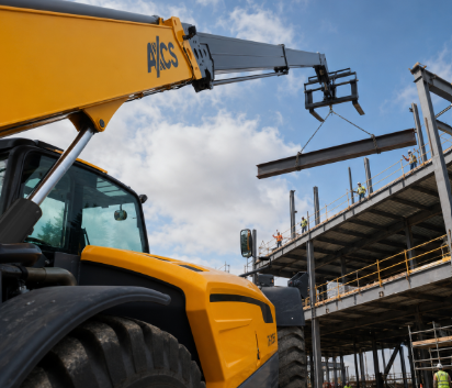Yellow JCB telehandler crane lifting steel beam at construction site with metal framework