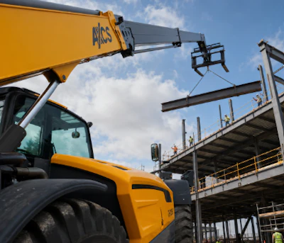 Yellow JCB telehandler crane lifting steel beam at construction site with metal framework