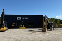 Five Star Equipment dealership with yellow excavators parked outside black warehouse building under clear sky