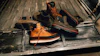 Orange and black work boots with safety gear arranged in a truck bed