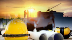 Yellow safety helmet with construction blueprints, ear protection, and workers on building site at sunset