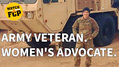 Army veteran and women's advocate in camouflage uniform standing before military vehicle