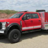 Red and silver fire truck with emergency equipment parked on rural road