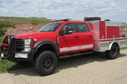 Red and silver fire truck with emergency equipment parked on rural road