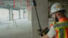 Construction worker using laser level tool on concrete wall at job site