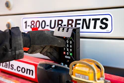 Worker using payment terminal on rental equipment truck with 1-800-UR-RENTS phone number and tools visible