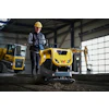 Construction worker operating yellow Wacker Neuson compactor in industrial warehouse setting