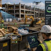 Construction worker sorting waste materials at job site with Chuck container and waste diversion statistics dashboard.
