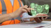 Construction worker in orange safety vest using tablet with green holographic sustainability and environmental monitoring icons