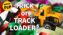 Yellow toy track loader with text overlay reading 'Trick or Track Loader' and 'Watch FCP' badge among colorful toy vehicles
