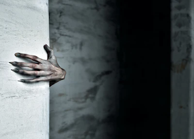 Sculptural hand emerging from white wall in dramatic lighting against dark background