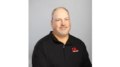 Professional headshot of middle-aged man with goatee wearing black Ultimate Lineman polo shirt against gray background