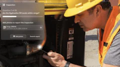 Construction worker in hard hat and safety vest inspecting hydraulic equipment during site inspection