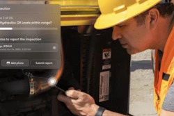 Construction worker in hard hat and safety vest inspecting hydraulic equipment during site inspection