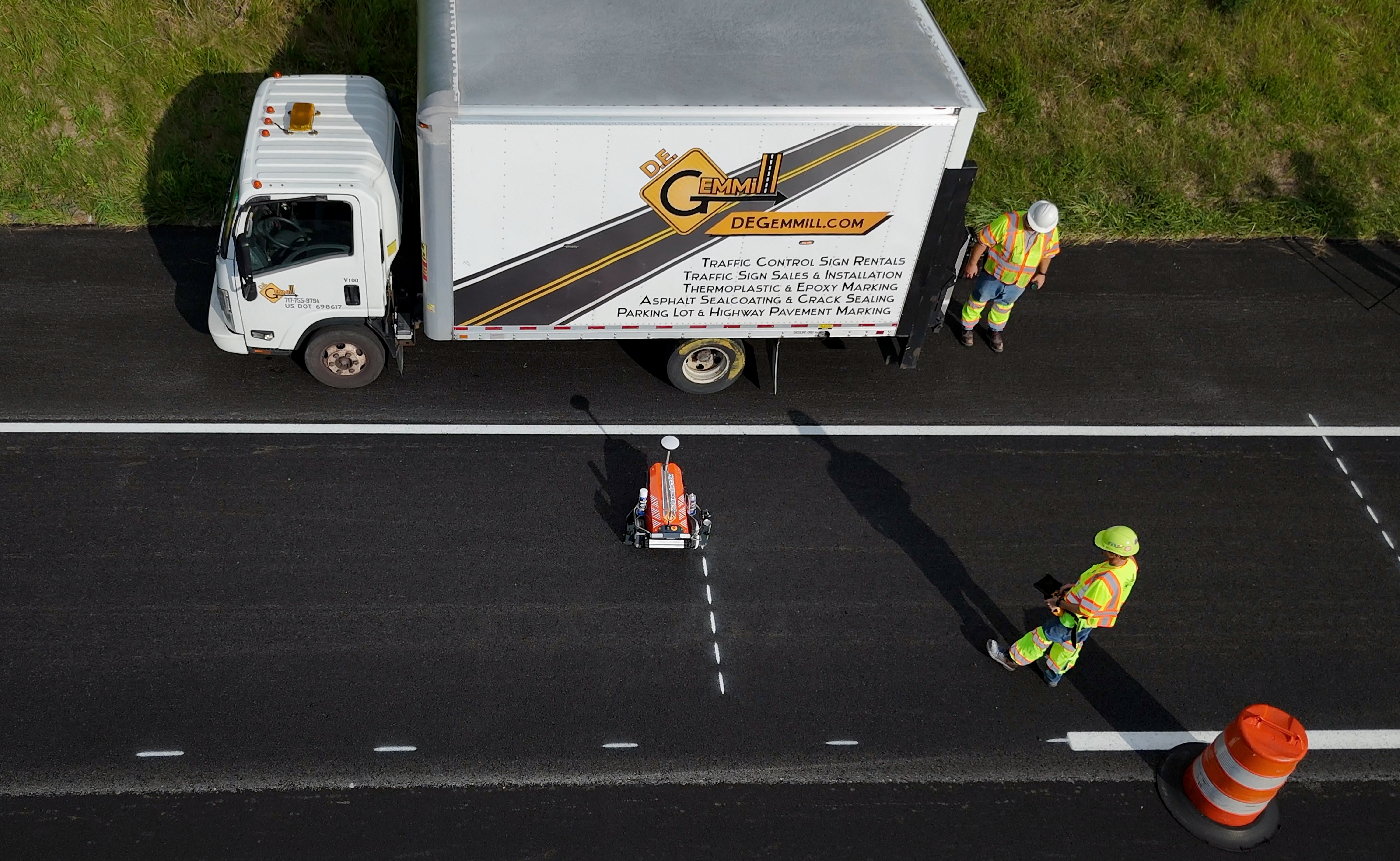 Overhead view of white Cargill food service truck parked on asphalt road with workers in safety gear and construction equipment nearby