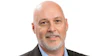 Professional headshot of a bald man with gray beard wearing a black blazer and light blue shirt
