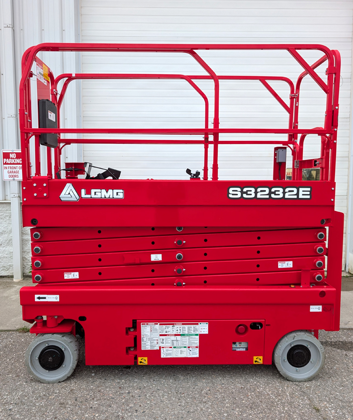 Red LGMG S3232E electric scissor lift with safety railings and control panel displayed against white garage door
