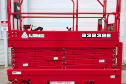 Red LGMG S3232E electric scissor lift with safety railings and control panel displayed against white garage door