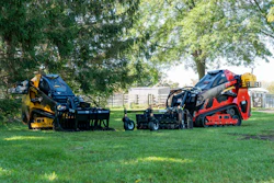 Yellow and red landscaping compactor equipment displayed on grass with trees in background