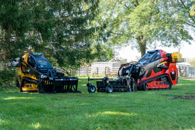 Yellow and red landscaping compactor equipment displayed on grass with trees in background