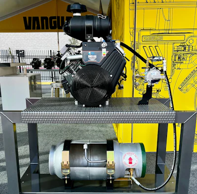 Industrial engine and air compressor system displayed on metal platform with Vanguard branding visible in background showroom.