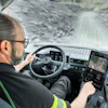 Truck driver navigating snowy mountain road from cabin interior view