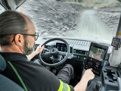 Truck driver navigating snowy mountain road from cabin interior view